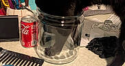 Prettygirl is registered to the contest to win money with this photo: animal, black_cat, black_fur, bottle, claw, cluttered_surface, comb, countertop, curious_cat, domestic_cat, glass_jar, household_items, indoor, papers, pens, pet, soda_can, spray_bottle, stationery, table