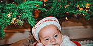 Jaxson joined the competition — help win amazing prizes! baby, blanket, blue_eyes, christmas, cute, decorations, face, festive, holiday, holiday_spirit, indoors, infant, lights, portrait, red_clothing, santa_hat, seasonal, sleepy, tree, white_fur