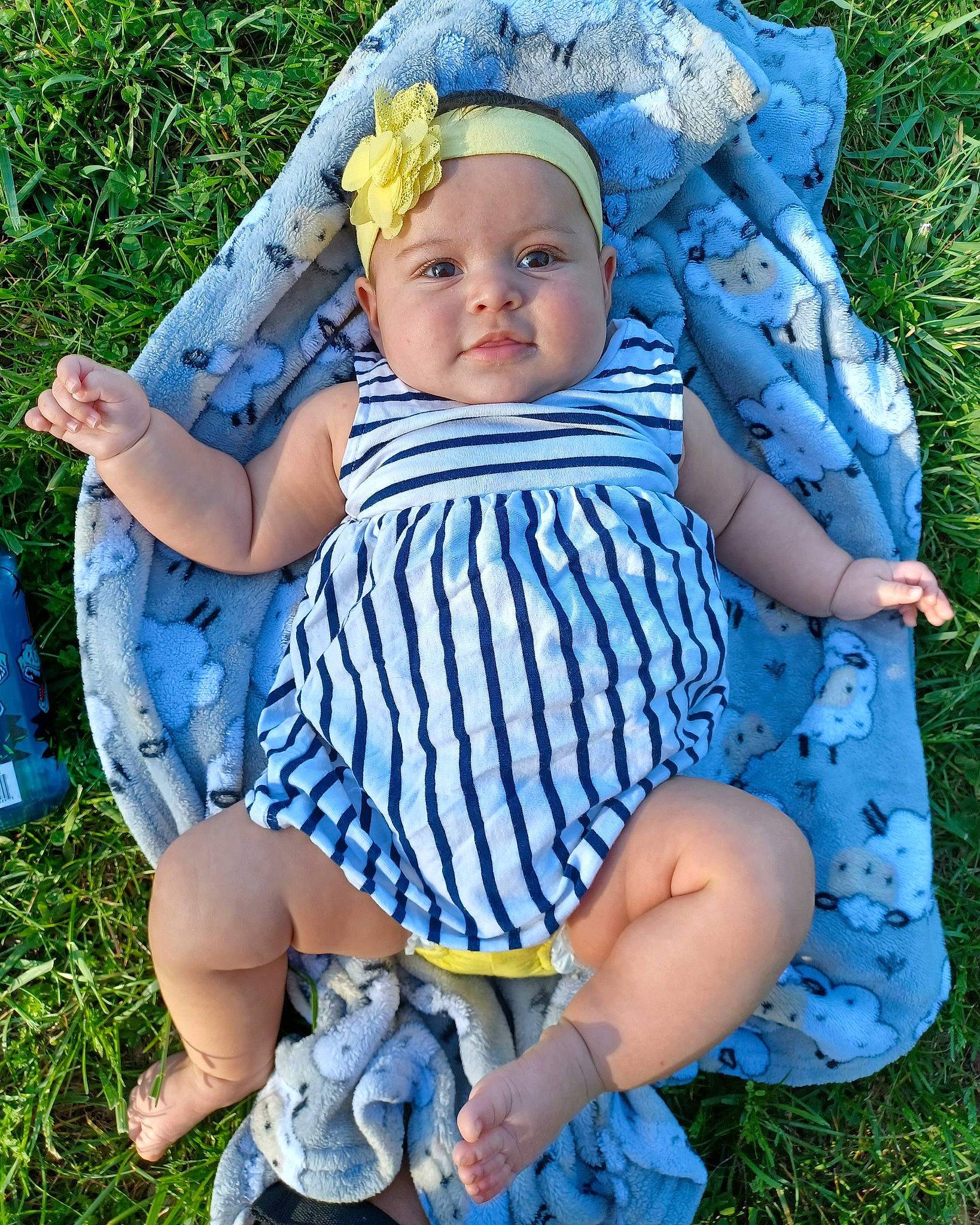 Reina is registered to the contest to win money with this photo: baby, baby_toddler_clothing, blue, dress, electric_blue, eye, facial_expression, fun, grass, green, happy, head, headwear, pattern, people_in_nature, person, plant, sandal, shoe, skin