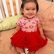 Mia Laia is registered to the contest to win money with this photo: child, toddler, girl, smiling, portrait, red_dress, tutu, hair_bows, white_shoes, sitting, couch, pillows, indoor, home, baby, fashion, happy, face, cherry_pattern, photography
