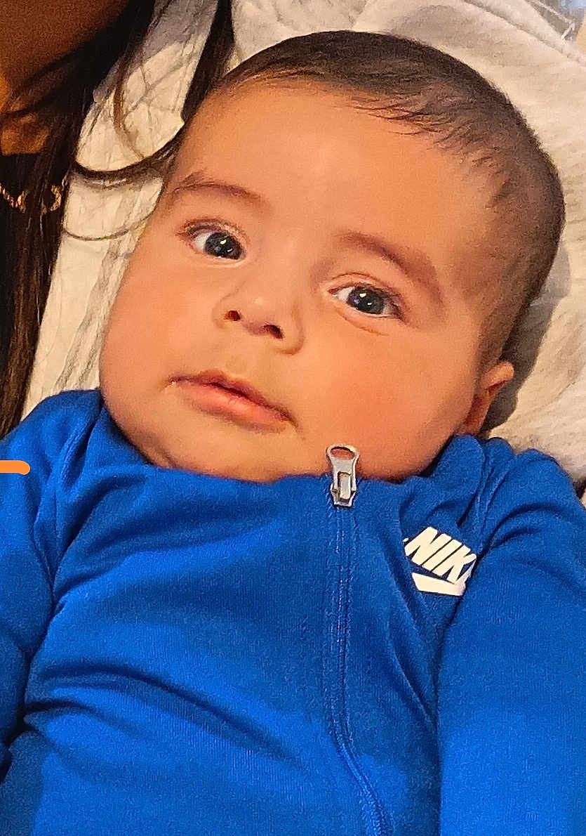 Izaak a rejoint le concours — aidez-le/la à gagner de superbes lots ! baby, child, face, blue_clothing, nike, zipper, portrait, indoor, person, young_child, curious, closeup, head, skin, eyebrows, hair, eyes, mouth, expression, cozy