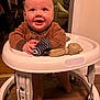 Cole is registered to the contest to win money with this photo: baby, child, walker, toy, teether, brown_clothing, smiling, happy, indoor, floor, wooden_floor, furniture, living_room, person, face, hands, legs, footwear, infant, cute
