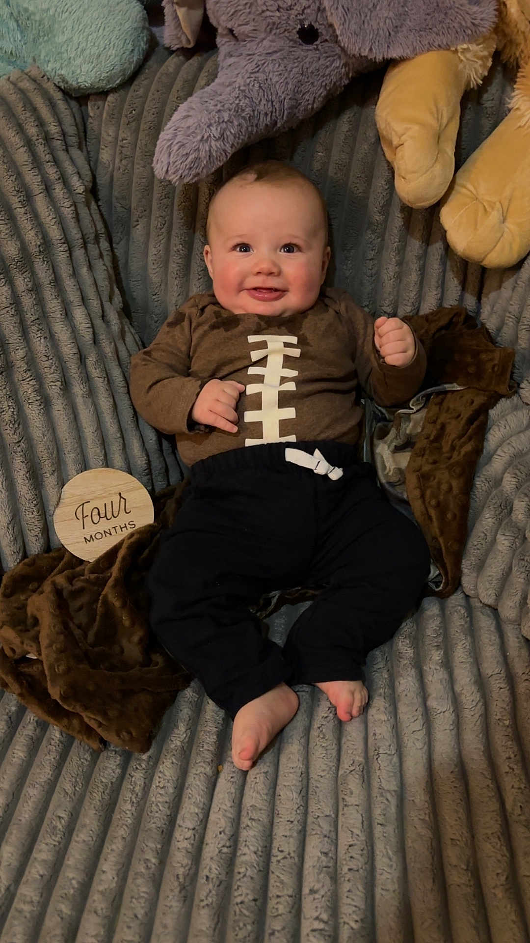 Cole joined the competition — help win amazing prizes! baby, infant, smiling, plush_toy, blanket, clothing, footwear, face, person, happy, indoors, cute, child, soft_toy, couch, portrait, baby_clothes, sitting, feet, cozy