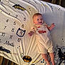 baby, infant, smiling, blanket, batman, milestone, numbers, car, overalls, clothing, floor, carpet, foot, person, cute, child, happy, indoors, portrait, toddler