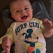 Ray joined the competition — help win amazing prizes! baby, smiling, mickey_mouse, surf_club, shirt, clothing, infant, happy, child, person, cute, lying_down, carpet, hand, face, head, indoor, playful, young_child, apparel