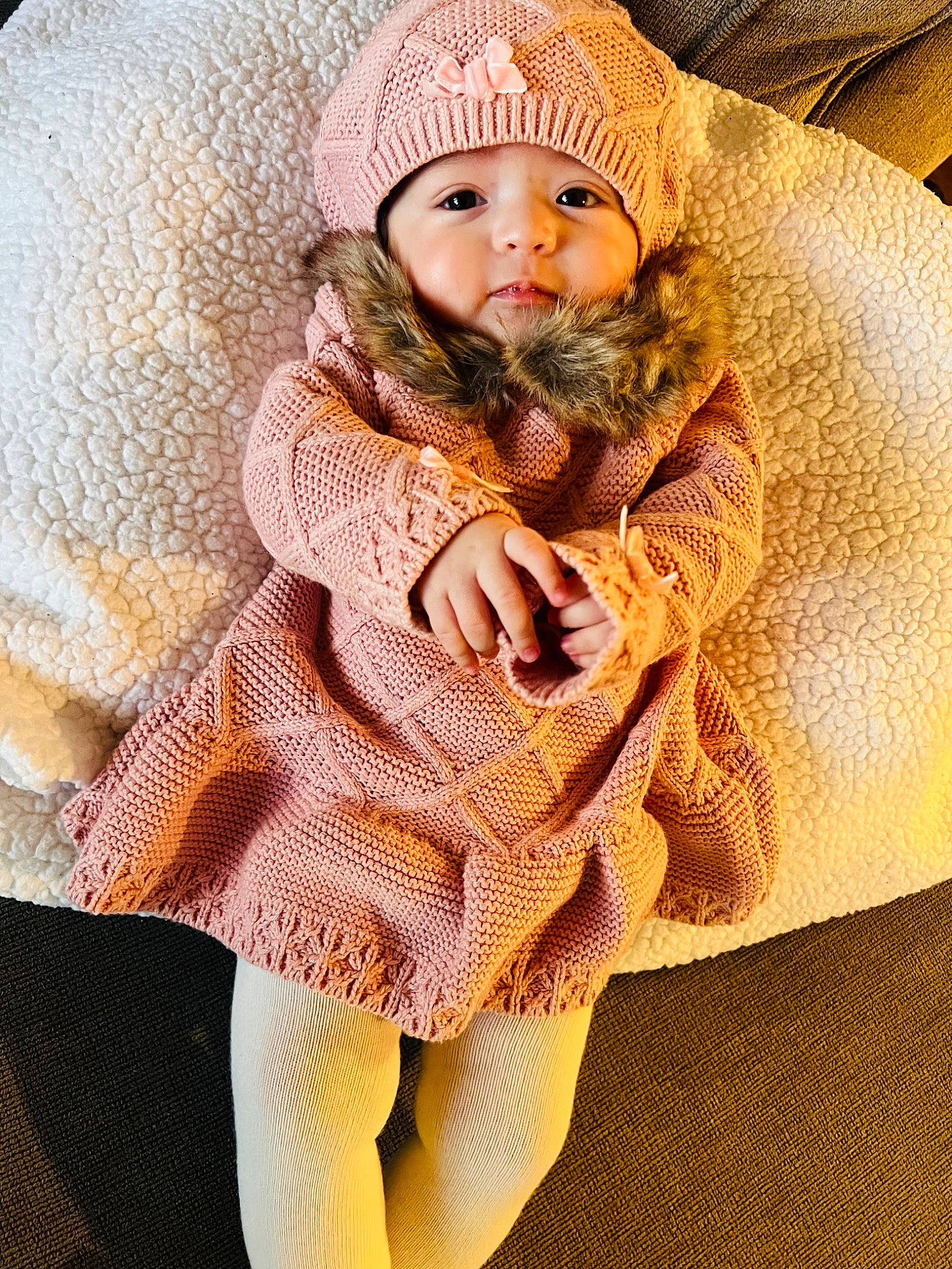 Ahlani is registered to the contest to win money with this photo: baby, baby_toddler_clothing, cap, child, comfort, dress, eye, face, fashion_accessory, fur, headwear, human_leg, knee, knit_cap, linens, pattern, person, skin, sleeve, textile