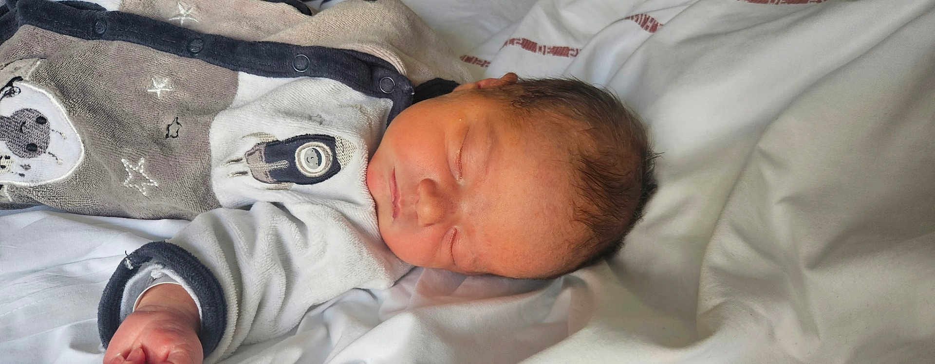 Ethan participe au concours pour gagner de l'argent avec cette photo : newborn, baby, sleeping, infant, onesie, bed, blanket, bedding, face, head, hair, closed_eyes, peaceful, tiny_hand, sleeve, fabric, cozy, portrait, soft_light, newborn_outfit