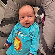 Ethan a rejoint le concours — aidez-le/la à gagner de superbes lots ! baby, buckle, cheeks, closeup, clothing, cozy, eyes, fabric, hand, happy, indoors, infant, lion_patch, monkey_graphic, newborn, onesie, portrait, seat, smile, straps