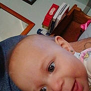 Thyra Eddy Dawn Loza is registered to the contest to win money with this photo: baby, close_up, face, earring, person, indoor, arm, clothing, blue_shirt, furniture, picture_frame, books, expression, curious, skin, head, child, portrait, smile, home