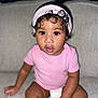 Mylonni is registered to the contest to win money with this photo: toddler, child, baby, indoor, couch, pink_onesie, headband, curly_hair, diaper, skin, sitting, face, expression, looking, person, young_child, cute, curious, home, portrait