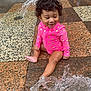 Mylonni is registered to the contest to win money with this photo: toddler, child, water, splash, pink_swimsuit, curly_hair, tile_floor, fountain, playful, outdoor, wet, happy, sitting, polka_dots, young_child, fun, summer, cute, small, joyful