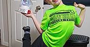 Eli joined the competition — help win amazing prizes! child, boy, smiling, portrait, indoor, soccer, basketball, sports, jersey, neon_green, black_pants, snow_globe, instant_snow_maker, toy, thumbs_up, posing, door, laundry_basket, rug, home