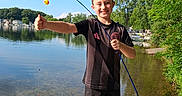 Eli joined the competition — help win amazing prizes! boy, child, clouds, dock, fish, fishing, fishing_rod, lake, nature, outdoor, portrait, reflection, sandals, shorts, sky, smiling, summer, sunny, trees, waterfront
