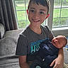 Eli is registered to the contest to win money with this photo: child, newborn, baby, siblings, brother, smiling, sleeping, portrait, indoors, couch, sitting, window, daylight, family, holding, infant, clothing, socks, home, outdoor_view