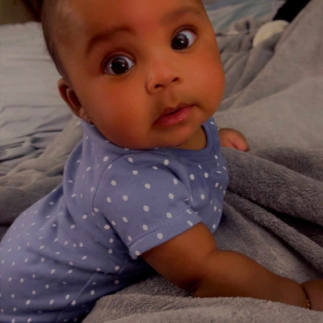 Lyriq is registered to the contest to win money with this photo: baby, bed, bedroom, blanket, bodypart, couch, crawling, face, finger, furniture, hand, happy, head, indoors, pattern, person, photography, portrait, room, smile