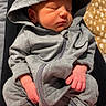baby, newborn, sleeping, hoodie, gray_clothing, infant, person, hands, feet, blanket, plush, soft, cute, resting, indoors, cozy, child, lap, relaxed, warm