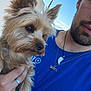 Toby a rejoint le concours — aidez-le/la à gagner de superbes lots ! animal, beard, blue_shirt, casual, closeup, cute, daytime, dog, friendship, fur, hand, human, man, necklace, outdoor, person, pet, portrait, sky, street_lamp