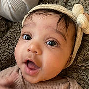 Gianna is registered to the contest to win money with this photo: baby, blanket, child, closeup, clothing, cozy, curious, cute, expression, eyes, face, flower, hand, headband, infant, mouth, portrait, skin, texture, young