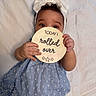 Gianna is registered to the contest to win money with this photo: baby, blanket, blue_dress, bow, child, curious, cute, dress, eyes, face, hand, headband, indoor, infant, lying_down, peeking, portrait, sign, soft_lighting, wooden_sign