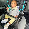 baby, car_seat, pacifier, infant, child, smiling, clothing, hoodie, shoes, seatbelt, vehicle_interior, car, yellow_pants, gray_jacket, happy, cute, sitting, person, young_child, indoors