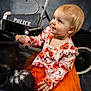 Isabelle joined the competition — help win amazing prizes! toddler, child, pumpkin, orange_tutu, halloween, cauldron, toy_car, police, black_pumpkin, costume, playful, cute, indoor, portrait, smiling, curious, festive, baby, blonde_hair, decor