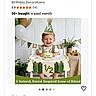 baby, boy, birthday, cone_hat, high_chair, banner, balloon, party, celebration, smile, green, table, plant, wooden_toy, half_birthday, decoration, child, indoor, portrait, happy