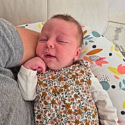 Camille a rejoint le concours — aidez-le/la à gagner de superbes lots ! baby, infant, sleepy, floral_outfit, pillow, arm, gray_shirt, hand, cute, resting, indoor, person, child, newborn, pattern, fabric, comfort, closeup, face, skin