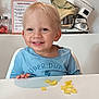 Luka a rejoint le concours — aidez-le/la à gagner de superbes lots ! toddler, child, smiling, blue_shirt, table, snacks, kitchen, mixer, plant, weekly_planner, face, happy, indoor, light_blond_hair, person, sitting, food, white_table, home, cute