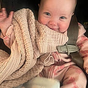 Rowen joined the competition — help win amazing prizes! baby, infant, car_seat, seatbelt, blanket, knit_blanket, smile, rosy_cheeks, bright_eyes, cozy, onesie, pink_pattern, hand, buckle, fabric_texture, portrait, closeup, soft_lighting, happy, seat