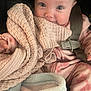 baby, infant, car_seat, seatbelt, blanket, knit_blanket, onesie, pink, cheeks, big_eyes, face, closeup, portrait, smiling, cozy, soft_texture, buckle, hand, gaze, adorable