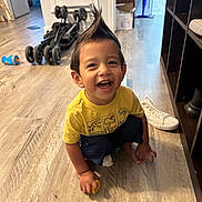 Avian is registered to the contest to win money with this photo: barefoot, candid, child, dinosaur_shirt, expression, flooring, hair_spike, happy, indoor, playing, portrait, room, shelf, smile, sneaker, stroller, toddler, toy, wooden_floor, yellow_shirt