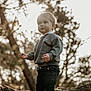 bokeh, casual_clothing, child, curious, cute, daylight, exploration, forest, innocence, nature, outdoor, pants, portrait, rock, standing, sunlight, sweater, toddler, trees, young_child