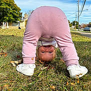 Elsie joined the competition — help win amazing prizes! toddler, child, grass, outdoor, playful, smiling, upside_down, pants, sneakers, blue_sky, tree, house, sidewalk, street, daylight, fun, happy, person, nature, casual