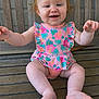 Brennley is registered to the contest to win money with this photo: baby, child, smiling, bench, wood, outdoor, pink_clothing, floral_pattern, happy, cute, sitting, infant, arms, legs, toes, face, portrait, young_child, casual, daylight