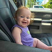 Brennley is registered to the contest to win money with this photo: baby, child, smile, car_seat, purple_clothing, polka_dot, red_hair, blue_eyes, vehicle_interior, window, sunlight, trees, outdoor, happy, portrait, infant, seatbelt, skin, person, daytime