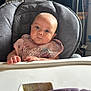 baby, high_chair, bib, food, spoon, bowl, indoor, child, blue_eyes, face, feeding, table, curious, messy, person, kitchen, furniture, clothing, infant, expression