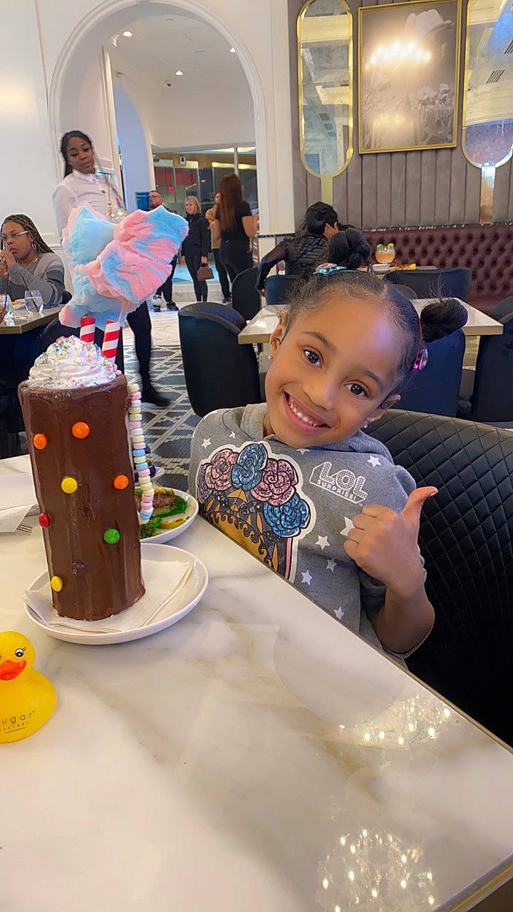 Kassidy is registered to the contest to win money with this photo: birthday, birthday_cake, cake, chair, child, event, food, fun, happy, head, icing, joy, leisure, person, plate, room, sitting, smile, t_shirt, table