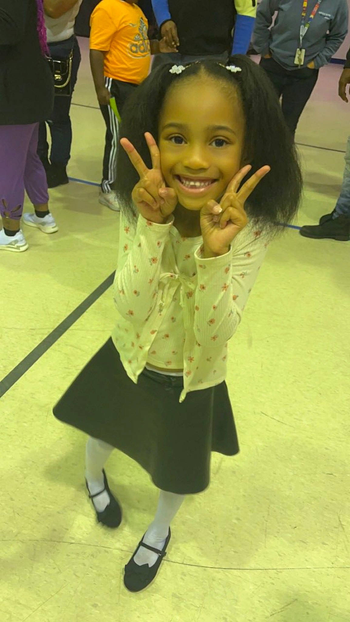 Kassidy is registered to the contest to win money with this photo: child, event, flooring, footwear, fun, gesture, happy, joint, joy, leg, leisure, outerwear, person, room, school_uniform, shoe, smile, snapshot, sneakers, sock