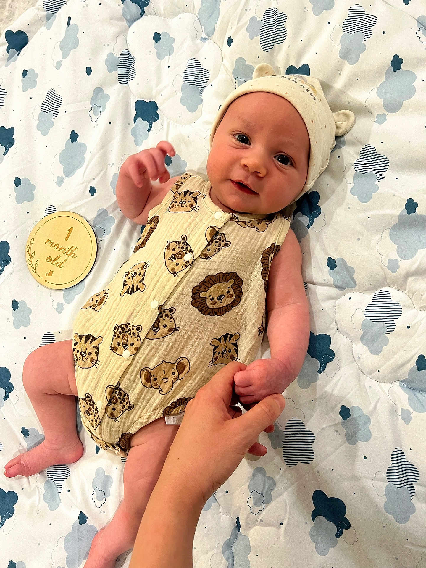 Leo joined the competition — help win amazing prizes! baby, infant, child, hand, blanket, pattern, animal_print, onesie, hat, milestone, wooden_disk, cloud_pattern, skin, cute, holding_hand, lying_down, indoors, soft_lighting, smiling, person