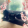 cat, black_cat, couch, window, greenery, flower, cherry_blossom, petals, indoor, relaxing, soft_light, nature, plant, cozy, resting, animal, feline, spring, decor, peaceful
