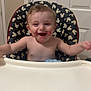Andrew joined the competition — help win amazing prizes! baby, high_chair, mickey_mouse_pattern, smiling, messy_face, indoor, child, happy, feeding, plastic_bottle, arms_outstretched, light_skin, short_hair, mouth_open, toy, furniture, door, wall, baby_bottle, seat_cushion
