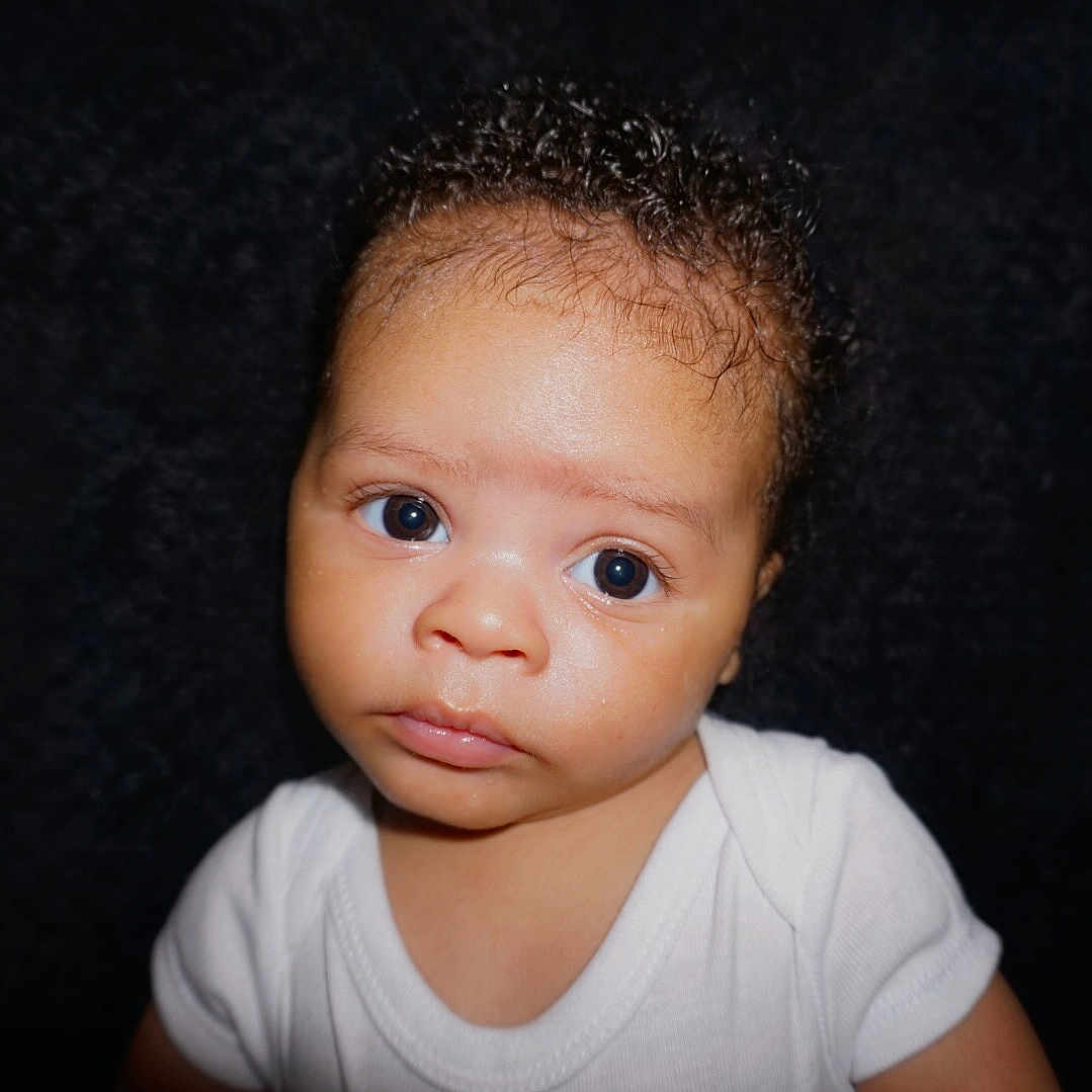 Lennox is registered to the contest to win money with this photo: accessories, baby, blackhair, bodypart, earring, face, frown, hair, happy, head, jewelry, neck, newborn, person, photography, portrait, sad, shoulder, skin, smile