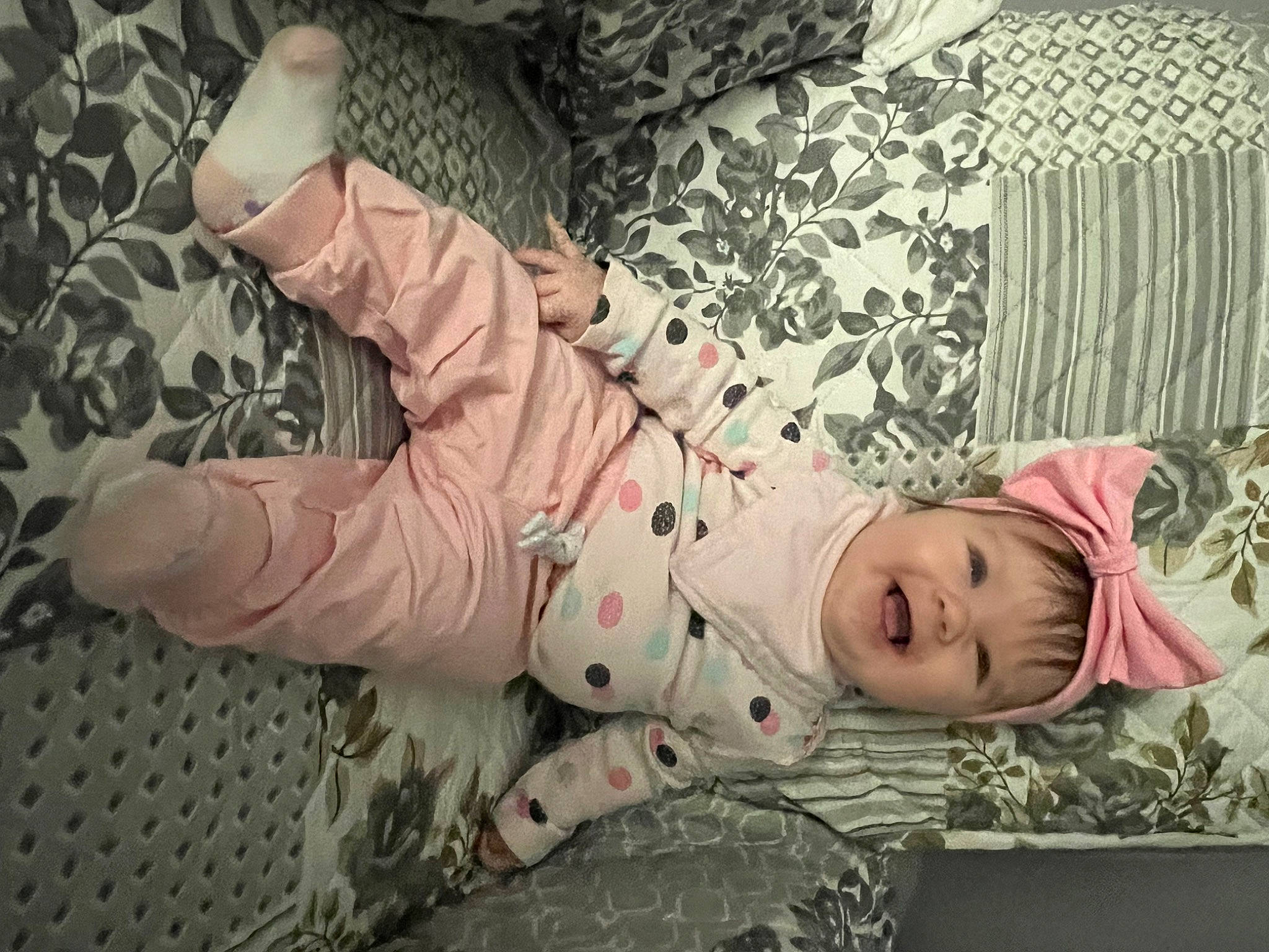 Charli is registered to the contest to win money with this photo: baby, baby_products, baby_toddler_clothing, camouflage, cheek, child, comfort, flooring, foot, gesture, grass, headwear, human_body, human_leg, joy, linens, military_camouflage, pattern, person, sitting