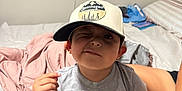 Emmanuel joined the competition — help win amazing prizes! child, boy, cap, hat, paw_patrol, tshirt, bed, blanket, pillow, winking, smiling, indoor, casual, cute, person, clothing, furniture, room, kid, portrait