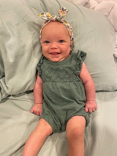 Layla is registered to the contest to win money with this photo: baby, baby_toddler_clothing, child, comfort, dress, eye, face, flash_photography, fun, grass, happy, head, headgear, iris, joy, person, skin, sleeve, smile, textile