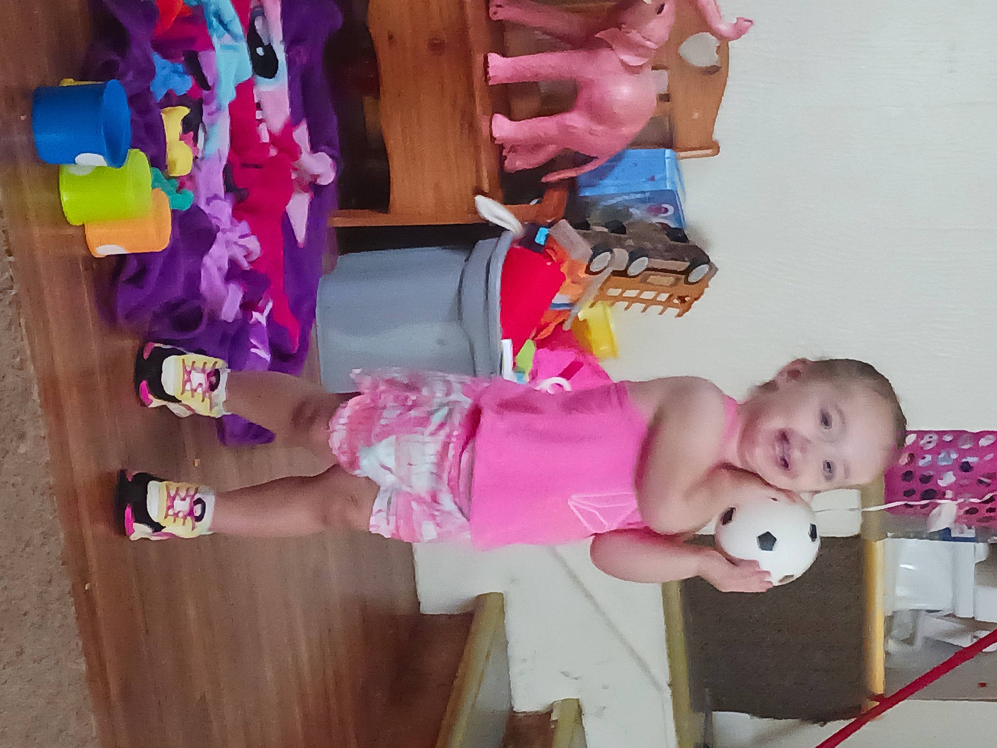 Isabella is registered to the contest to win money with this photo: baby, baby_products, baby_toddler_clothing, baby_toys, chair, child, clothing, dress, foot, fun, hand, joy, magenta, person, pink, room, sandal, smile, thigh, toddler