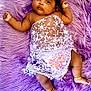 baby, infant, purple_rug, lace_clothing, headband, flower, anklet, barefoot, cute, portrait, soft_texture, lying_down, indoors, child, adorable, skin, small_hands, small_feet, decorative_cloth, peaceful