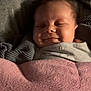 baby, smiling, blanket, cozy, sleeping, infant, closeup, face, child, indoors, comfort, soft, cute, relaxed, small, portrait, resting, peaceful, warm, seated