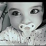 Scarlett is registered to the contest to win money with this photo: baby, pacifier, closeup, black_and_white, infant, face, eyes, blanket, clothing, heart_pattern, cute, child, portrait, soft_texture, young, adorable, babywear, sleepwear, newborn, expression