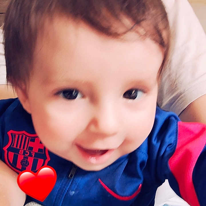 Livio participe au concours pour gagner de l'argent avec cette photo : baby, bodypart, clothing, couch, face, finger, furniture, hand, happy, head, heart, mouth, newborn, person, photography, portrait, shirt, smile, symbol, t_shirt